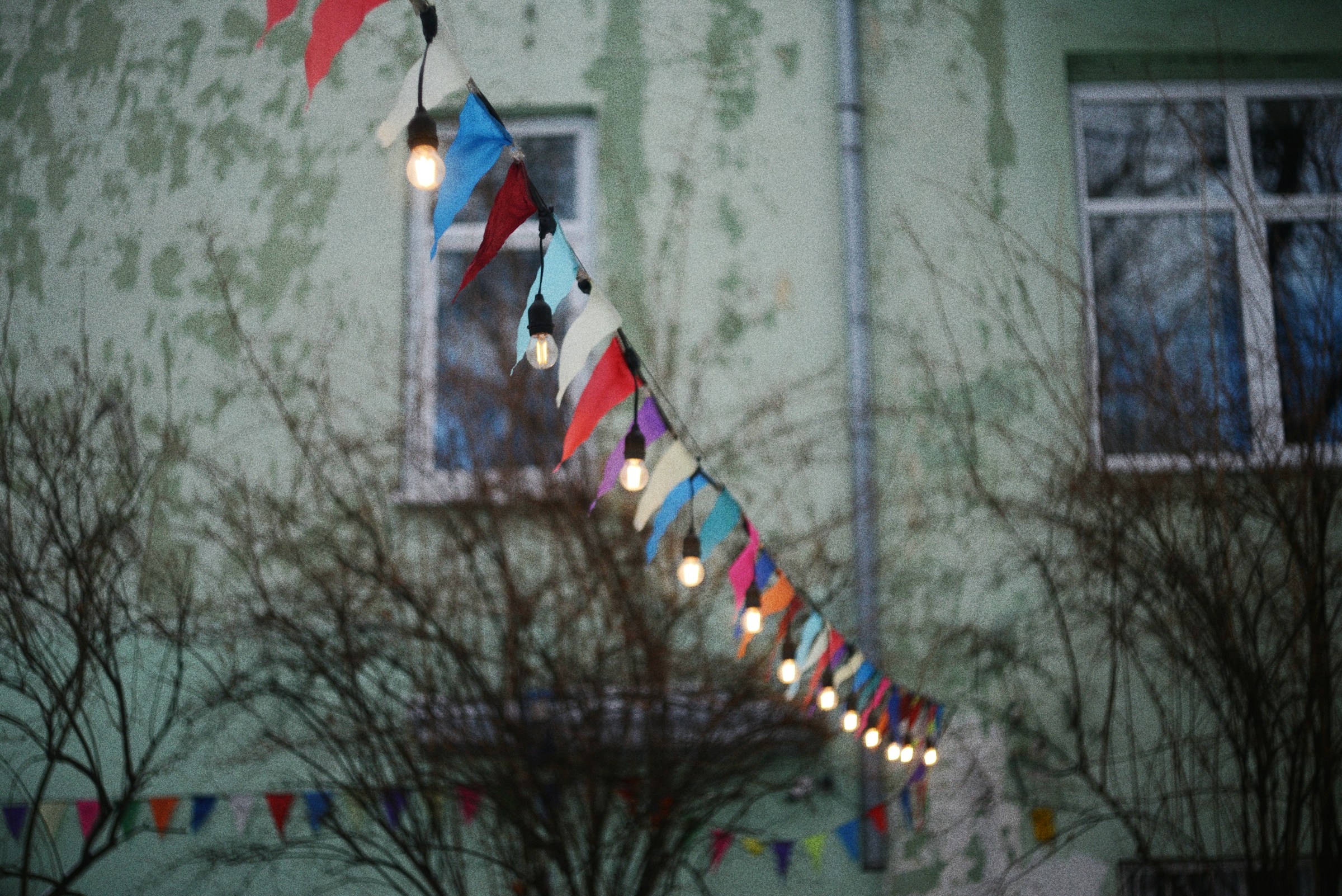 A backyard party under red and white bunting on Canada Day, guests around a picnic table